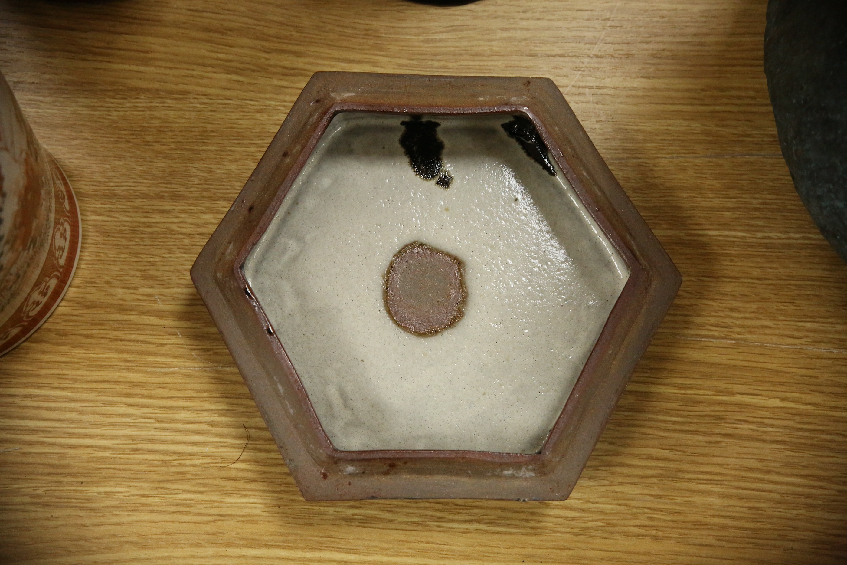 A Japanese studio tenmoku glazed hexagonal box and cover, unmarked, 18cm wide. Condition - good